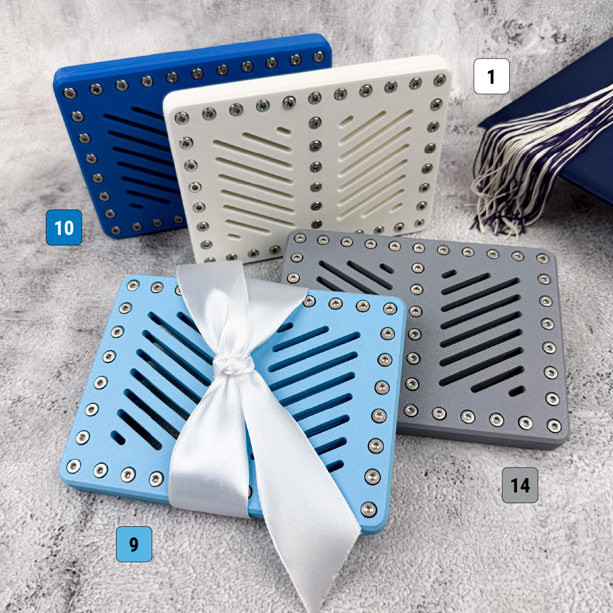 Blue, white, gray, and silver Lockup Duo graduation gift holders displayed with graduation cap and tassel