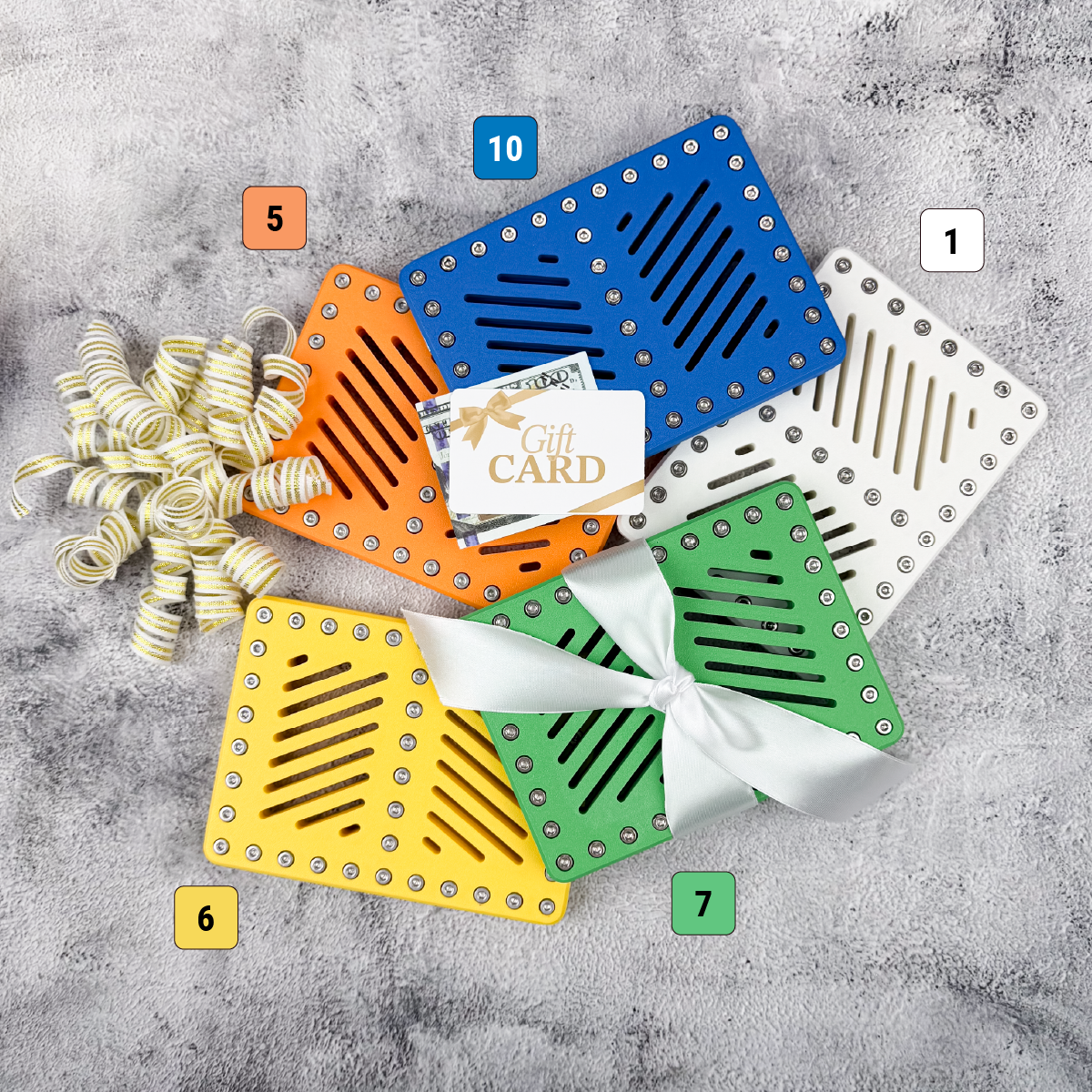 Orange, blue, white, green, and yellow graduation gift card holders displayed with cash and ribbon
