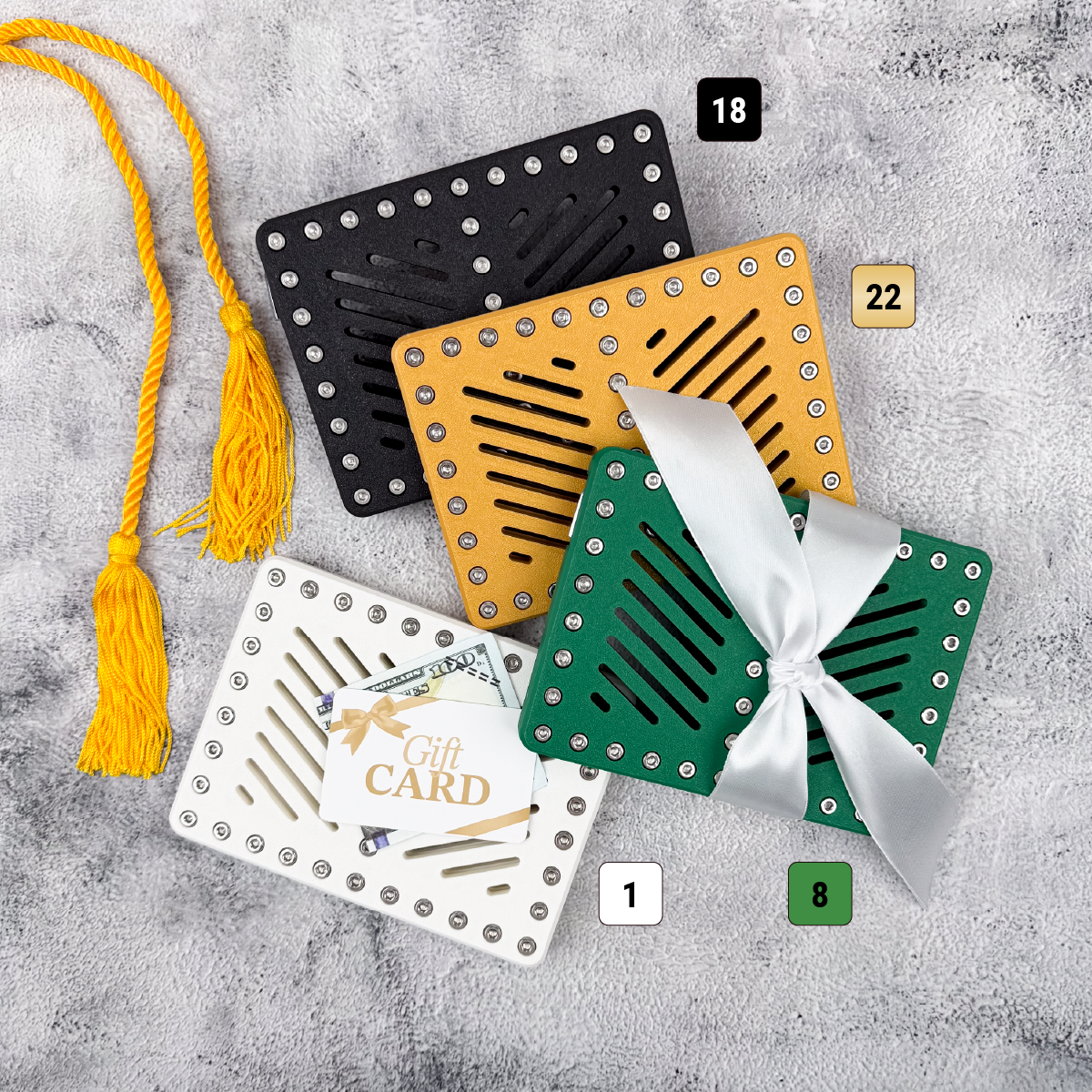 Black, gold, white, and green Lockup Duo graduation holders with graduation tassel and gift card